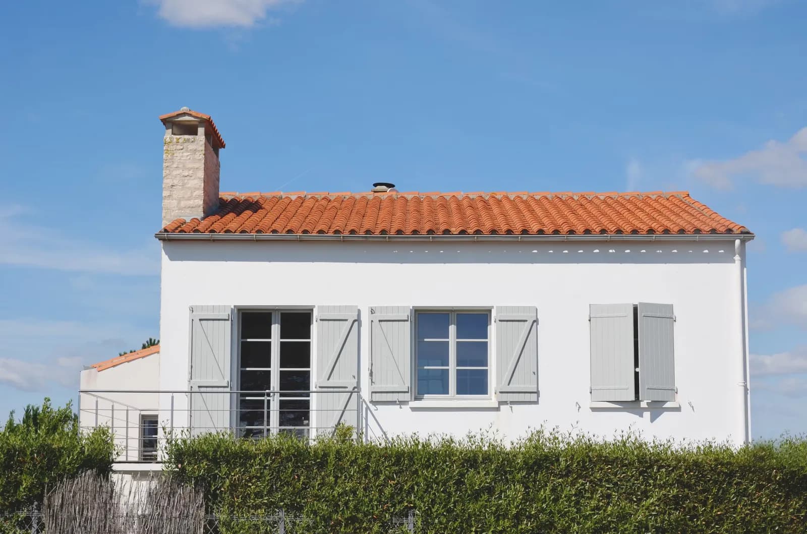 Façade de maison blanche aux volets gris ravalée en sud Loire