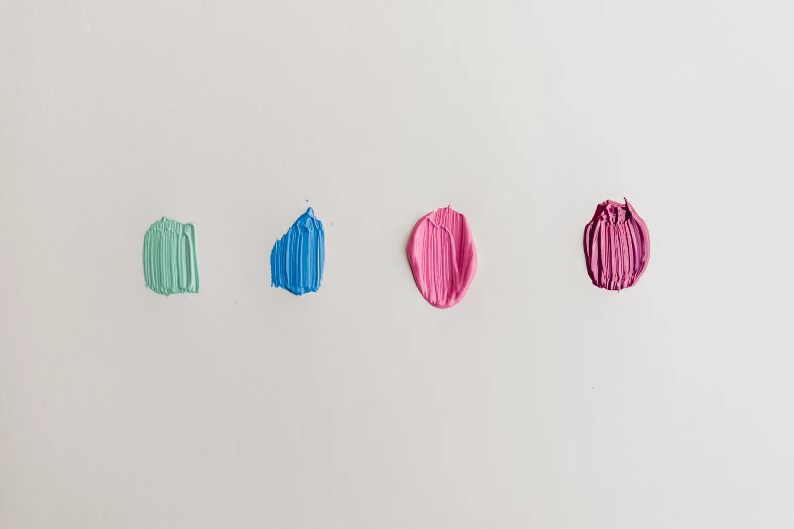 Échantillons de peinture, quatre teintes appliquées pour comparaison sur mur